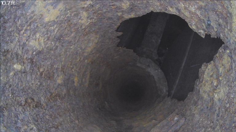 Sewer camera view showing damage inside a drain stack